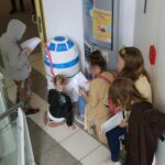 Kinder und Erwachsene vor einem Papp-R2-D2