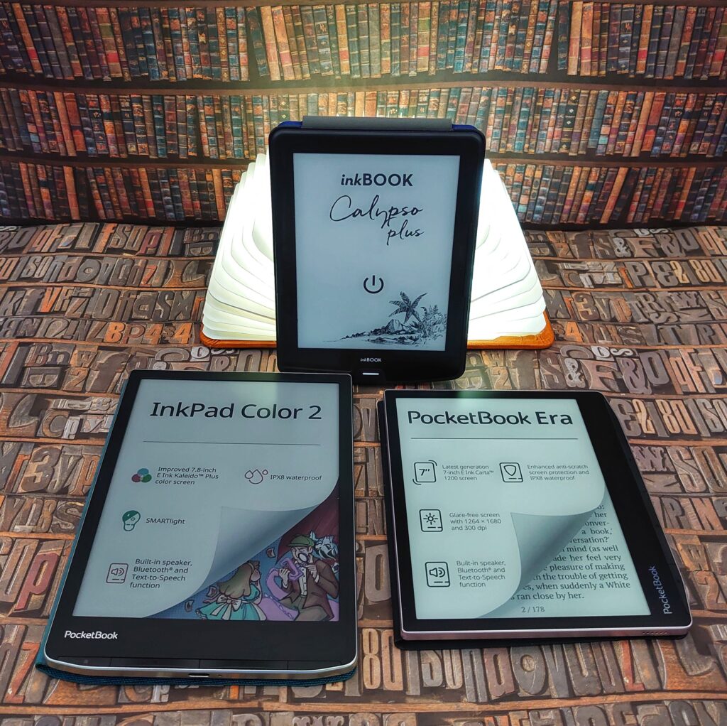 3 E-Book-Reader mit leuchtendem Buch als Dekoration